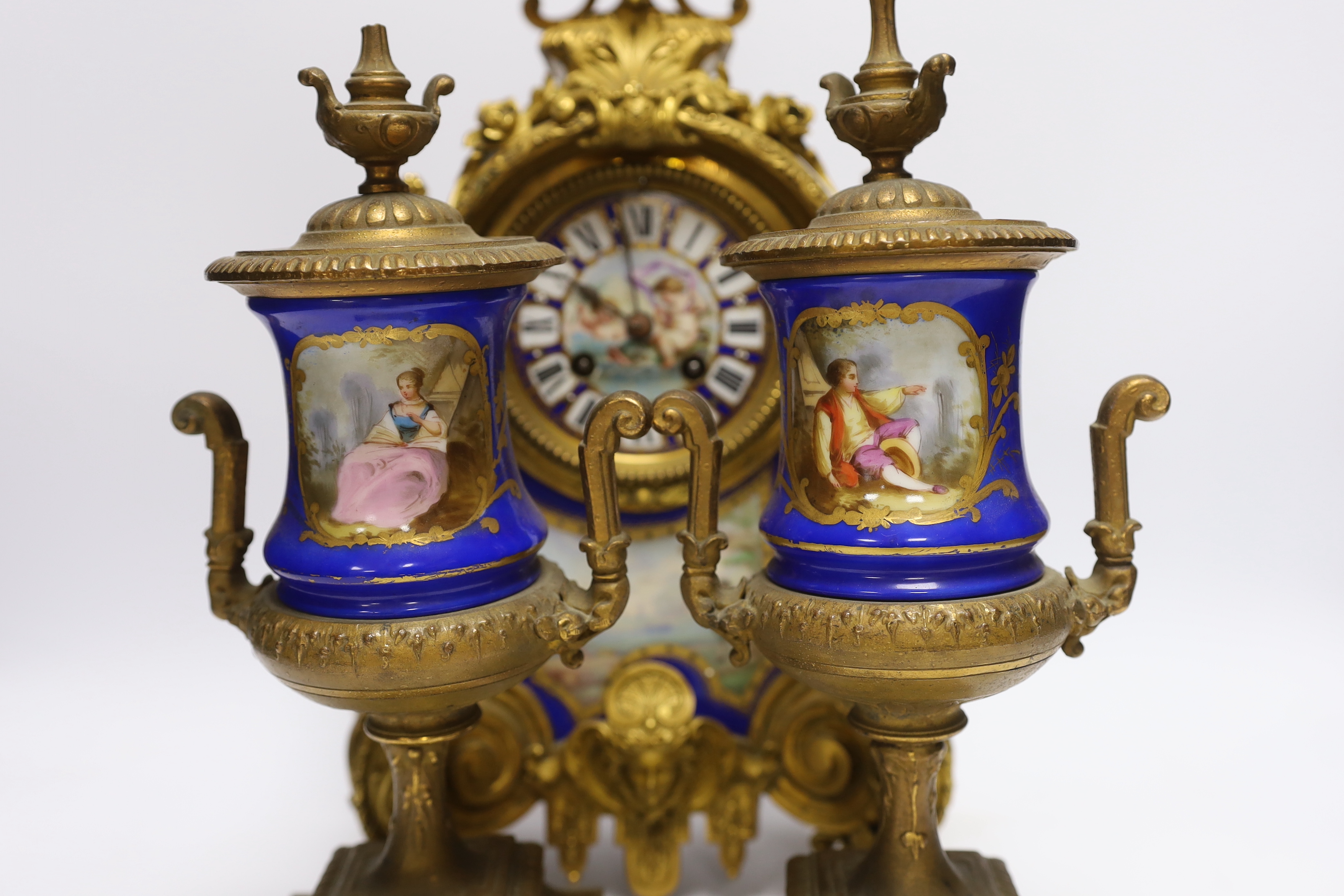 A Sevres style ormolu clock, Miller & Sons with two similar gilt spelter urns, pendulum no key, 44cm